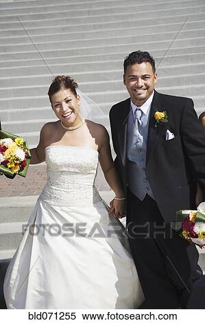 Stock Photography - Multi-ethnic bride and groom holding hands. Fotosearch