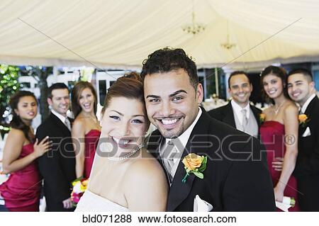 Stock Photo - Multi-ethnic bride and groom hugging. Fotosearch