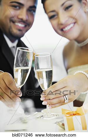 Multi-ethnic bride and groom toasting View Large Photo Image Stock Photograph - Multi-ethnic bride and groom toasting. Fotosearch