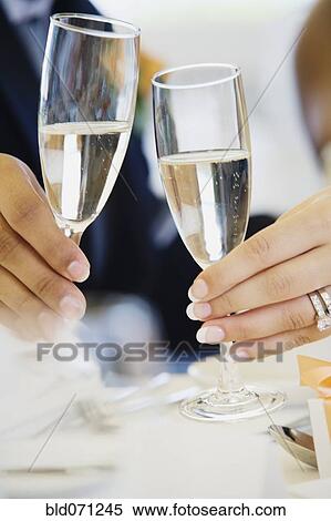 Stock Photography - Multi-ethnic bride and groom toasting. Fotosearch