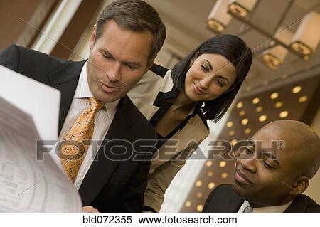 Multi-ethnic business people reviewing paperwork View Large Photo Image Stock Photography - Multi-ethnic business people reviewing paperwork. Fotosearch