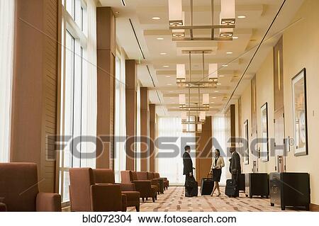 Picture - Multi-ethnic business people with suitcases in hotel. Fotosearch