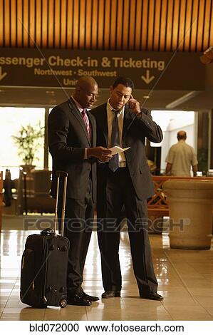 Stock Image - Multi-ethnic businessmen at airport. Fotosearch