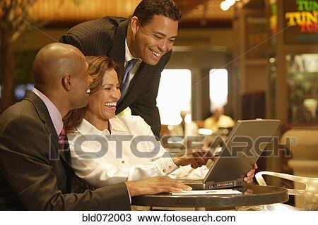 Multi-ethnic businesspeople laughing at laptop View Large Photo Image Stock Image - Multi-ethnic businesspeople laughing at laptop. Fotosearch