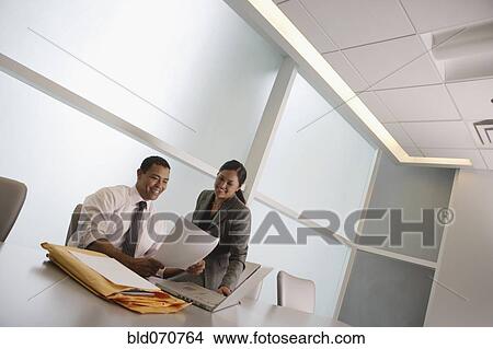 Picture - Multi-ethnic businesspeople looking at paperwork. Fotosearch