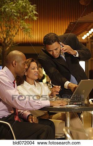 Picture - Multi-ethnic businesspeople looking at laptop. Fotosearch