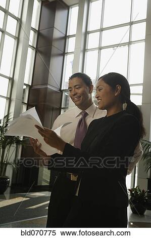 Stock Photography - Multi-ethnic businesspeople looking at paperwork. Fotosearch