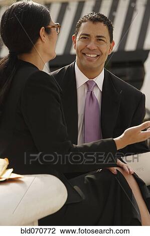Stock Image - Multi-ethnic businesspeople talking outdoors. Fotosearch