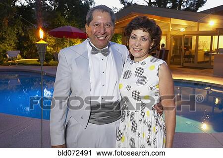 Stock Image - Multi-ethnic couple enjoying pool party. Fotosearch