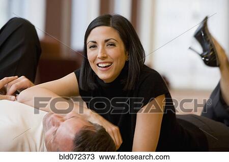 Stock Image - Multi-ethnic couple laying on floor. Fotosearch