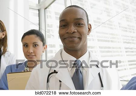 Multi-ethnic doctor and nurse looking confident View Large Photo Image Stock Photo - Multi-ethnic doctor and nurse looking confident. Fotosearch