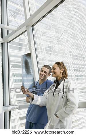 Stock Photography - Multi-ethnic doctor and nurse reviewing x-ray. Fotosearch