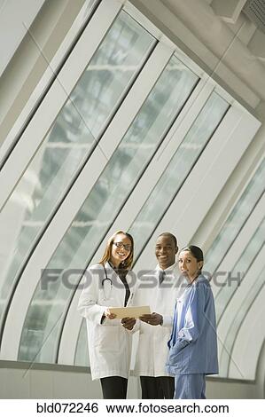 Stock Photograph - Multi-ethnic doctors and nurse posing by window. Fotosearch