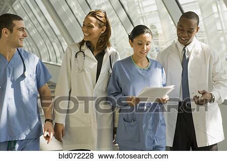 Multi-ethnic doctors and nurses in corridor View Large Photo Image Stock Photo - Multi-ethnic doctors and nurses in corridor. Fotosearch