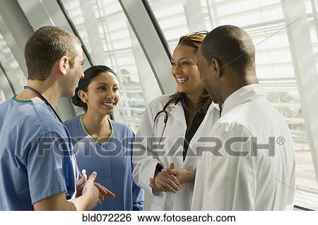 Stock Photograph - Multi-ethnic doctors and nurses talking. Fotosearch