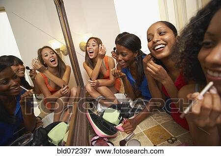 Multi-ethnic group of friends applying makeup View Large Photo Image Stock Photo - Multi-ethnic group of friends applying makeup. Fotosearch