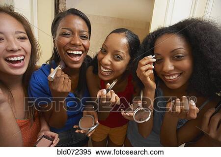 Stock Photography - Multi-ethnic group of friends applying makeup. Fotosearch