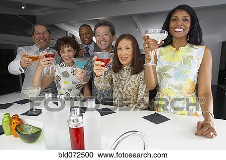 Multi-ethnic group of friends drinking cocktails at party View Large Photo Image Stock Image - Multi-ethnic group of friends drinking cocktails at party. Fotosearch