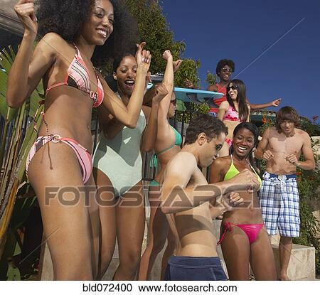 Stock Image - Multi-ethnic group of friends enjoying pool party. Fotosearch