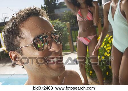 Stock Image - Multi-ethnic group of friends enjoying pool party. Fotosearch