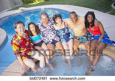 Stock Image - Multi-ethnic group of friends enjoying pool party. Fotosearch