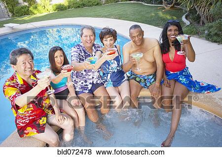 Stock Photo - Multi-ethnic group of friends enjoying pool party. Fotosearch
