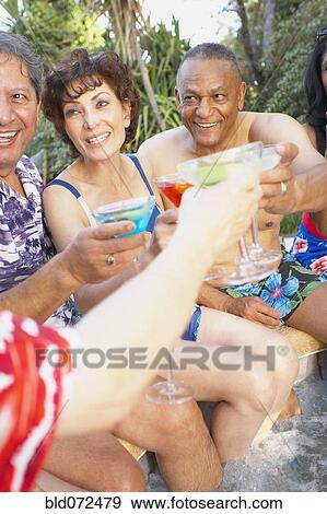 Stock Photo - Multi-ethnic group of friends enjoying pool party. Fotosearch