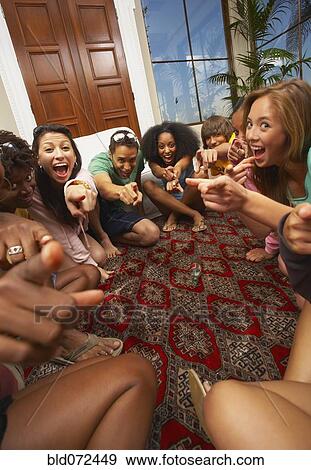 Multi-ethnic group of friends playing spin the bottle View Large Photo Image Stock Photo - Multi-ethnic group of friends playing spin the bottle. Fotosearch