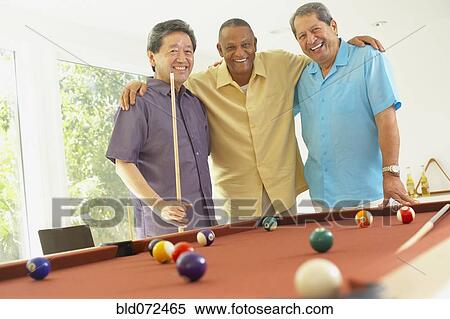 Stock Photography - Multi-ethnic group of friends playing pool. Fotosearch
