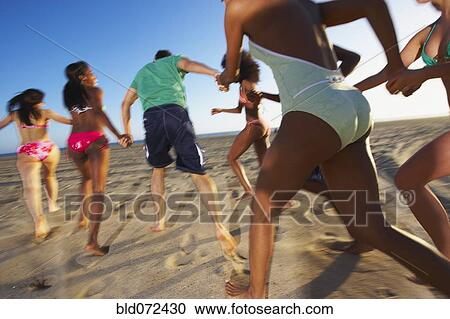Multi-ethnic group of friends running on beach View Large Photo Image Stock Image - Multi-ethnic group of friends running on beach. Fotosearch