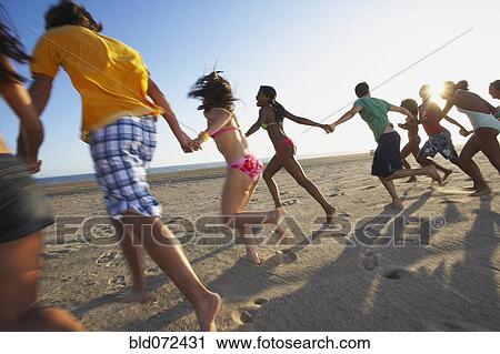 Multi-ethnic group of friends running on beach View Large Photo Image Stock Image - Multi-ethnic group of friends running on beach. Fotosearch