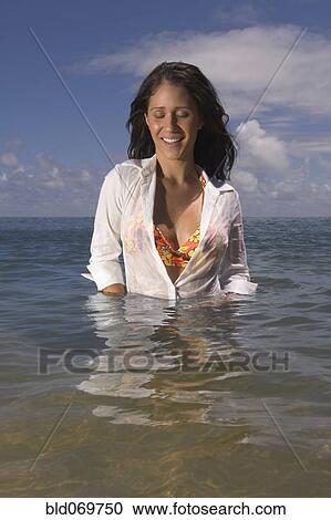 Stock Image - Pacific Islander woman standing in waist deep water. Fotosearch