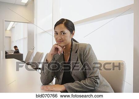 Stock Photograph - Portrait of Asian businesswoman at conference table. Fotosearch