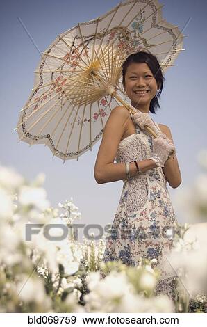 Stock Photo - Portrait of Asian woman holding parasol. Fotosearch