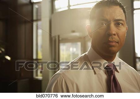 Stock Photograph - Portrait of Hispanic businessman in sunlight. Fotosearch