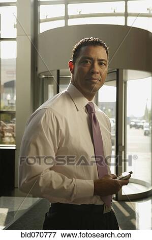 Portrait of Hispanic businessman holding electronic organizer View Large Photo Image Stock Photo - Portrait of Hispanic businessman holding electronic organizer. Fotosearch
