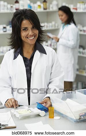 Stock Photography - Portrait of Hispanic female pharmacist in pharmacy. Fotosearch