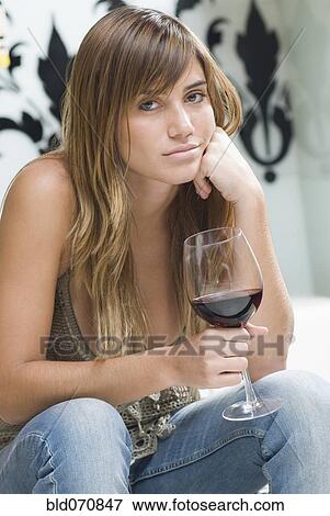 Stock Photo - Portrait of Hispanic woman holding wine glass. Fotosearch