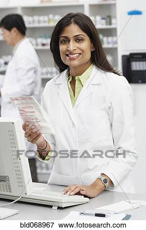 Stock Photo - Portrait of Indian female pharmacist in pharmacy. Fotosearch
