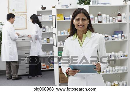 Stock Photo - Portrait of Indian female pharmacist in pharmacy. Fotosearch