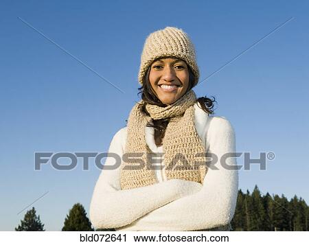 Stock Image - Portrait of mixed race woman smiling with arms crossed. Fotosearch