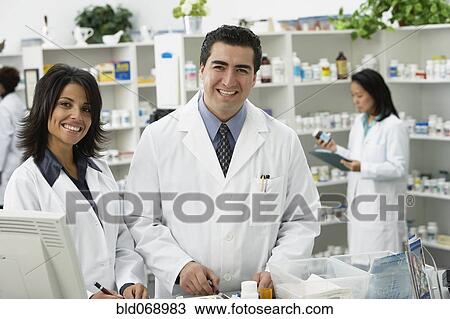 Stock Image - Portrait of pharmacists in pharmacy. Fotosearch