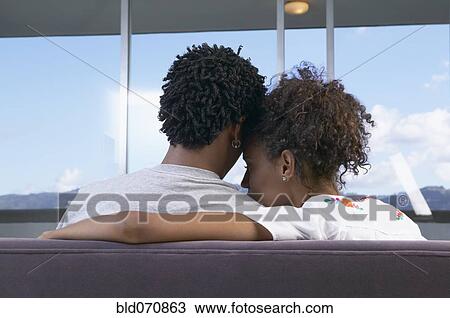 Rear view of African couple hugging on sofa View Large Photo Image Stock Image - Rear view of African couple hugging on sofa. Fotosearch