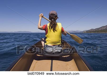 Rear view of woman paddling canoe View Large Photo Image Stock Photo - Rear view of woman paddling canoe. Fotosearch