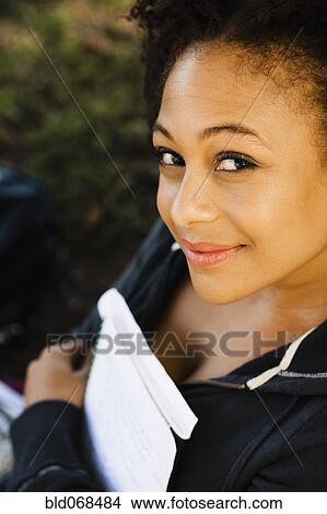 Smiling African woman holding book View Large Photo Image Picture - Smiling African woman holding book. Fotosearch