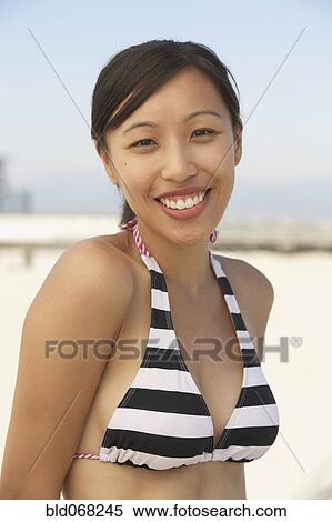 Smiling Asian woman wearing bikini at beach View Large Photo Image Stock Photography - Smiling Asian woman wearing bikini at beach. Fotosearch