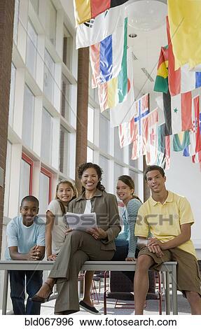Stock Photograph - Teacher and students posing in classroom. Fotosearch