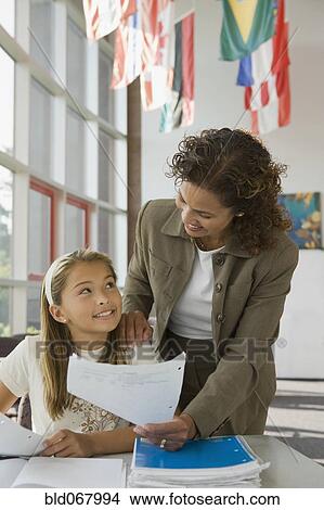 Picture - Teacher helping student wit homework. Fotosearch