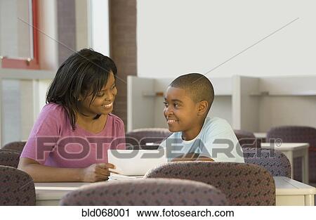 Stock Image - Teacher helping student with homework. Fotosearch