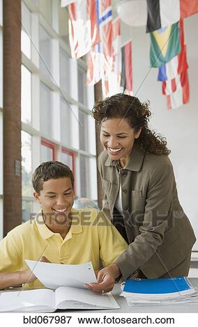 Stock Photo - Teacher helping student with homework. Fotosearch